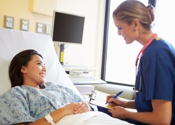 woman smiling with physician taking notes - 2240w